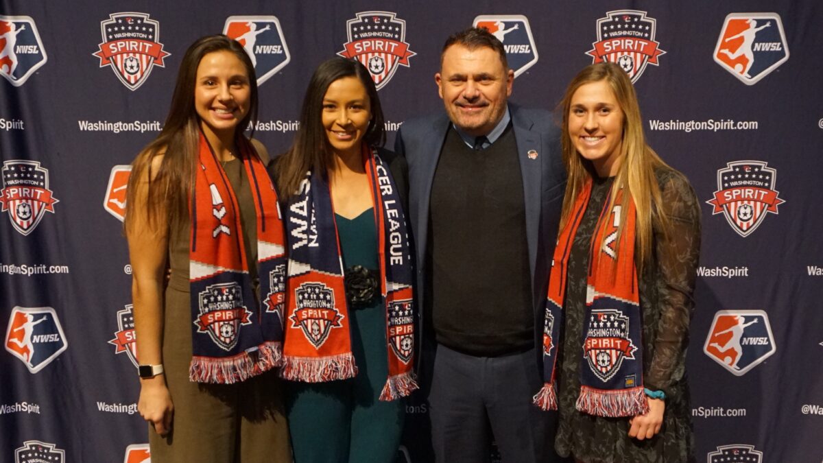 Richie Burke, the new Washington Spirit coach, poses with three of the NWSL team's.